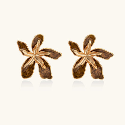 Gold-plated brass flower earrings with brown tortoiseshell enamel petals on cream background
