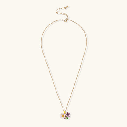 Gold-plated necklace with pink and purple enamel flower pendant featuring crystal accents on cream background
