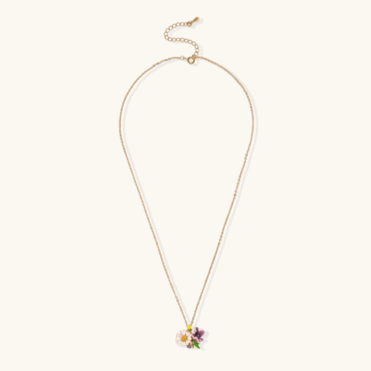 Gold-plated necklace with pink and purple enamel flower pendant featuring crystal accents on cream background
