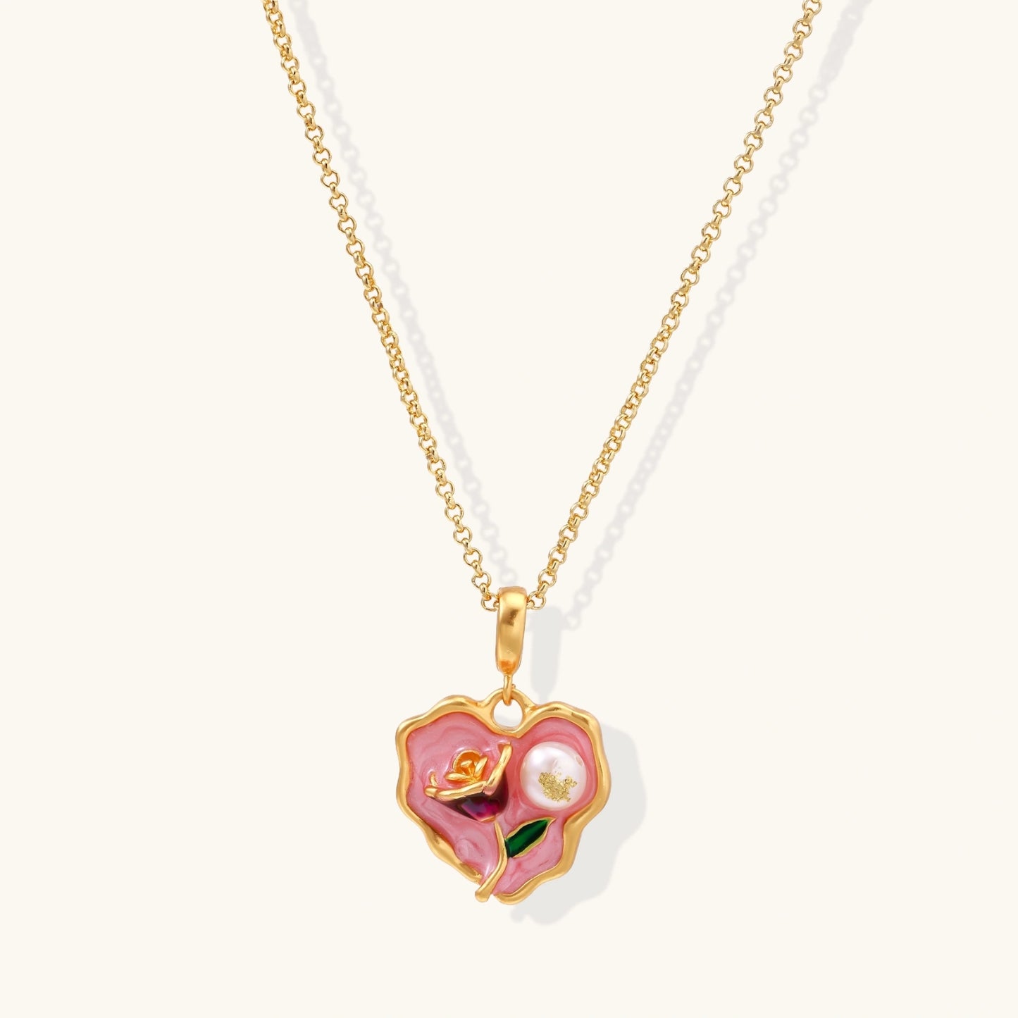 Heart-shaped pendant with pink enamel, rose design, freshwater pearl flower, and gold scalloped frame on delicate chain