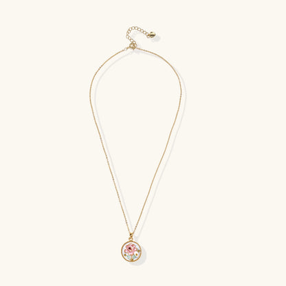 Gold-plated circular pendant with pink enamel rose, pearl background, and delicate beaded border on chain