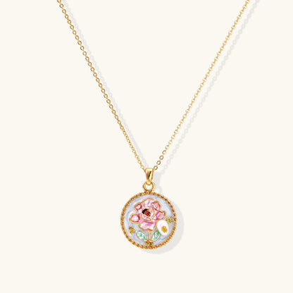 Gold-plated circular pendant with pink enamel rose, pearl background, and delicate beaded border on chain