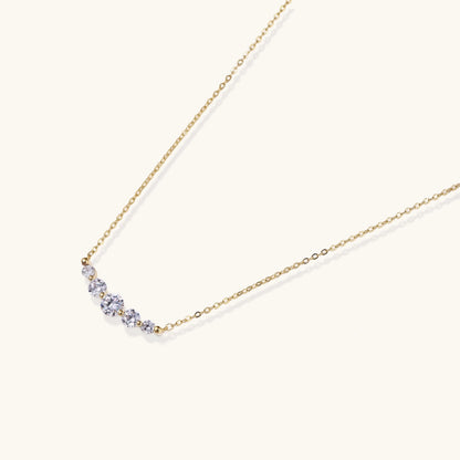 Delicate 14K gold-plated necklace with five graduated zirconia stones arranged in a curved arc on fine chain