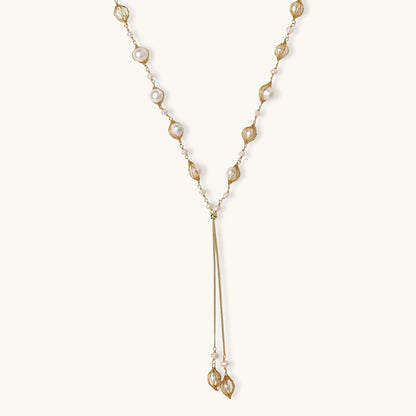 Adjustable gold lariat necklace with freshwater pearls nested in delicate cage settings and Y-shaped tassel drop